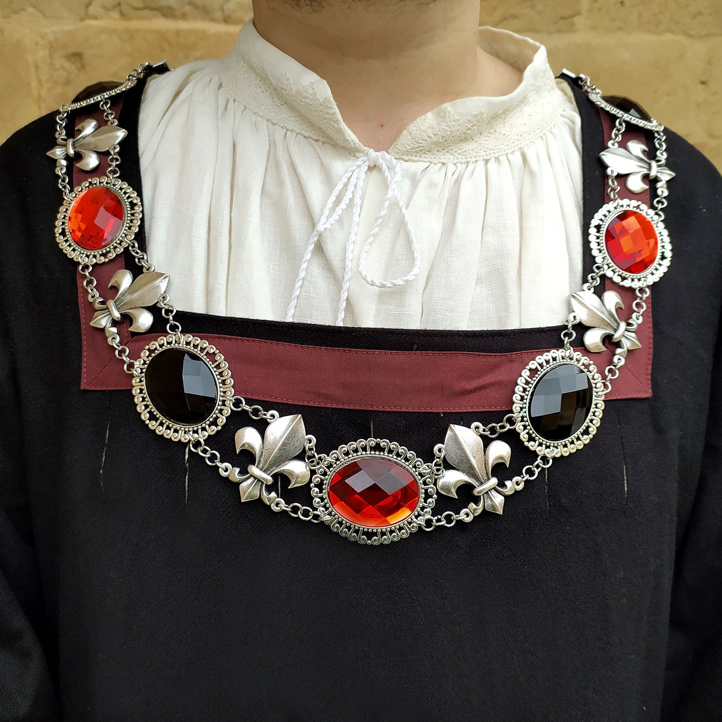 Fleur de Lis chain of office in antique silver finish, detail view of this collar on a model wearing a renaissance attire. influenced by the Renaissance era, is an ideal choice for a historical reenactment or fair.&nbsp;