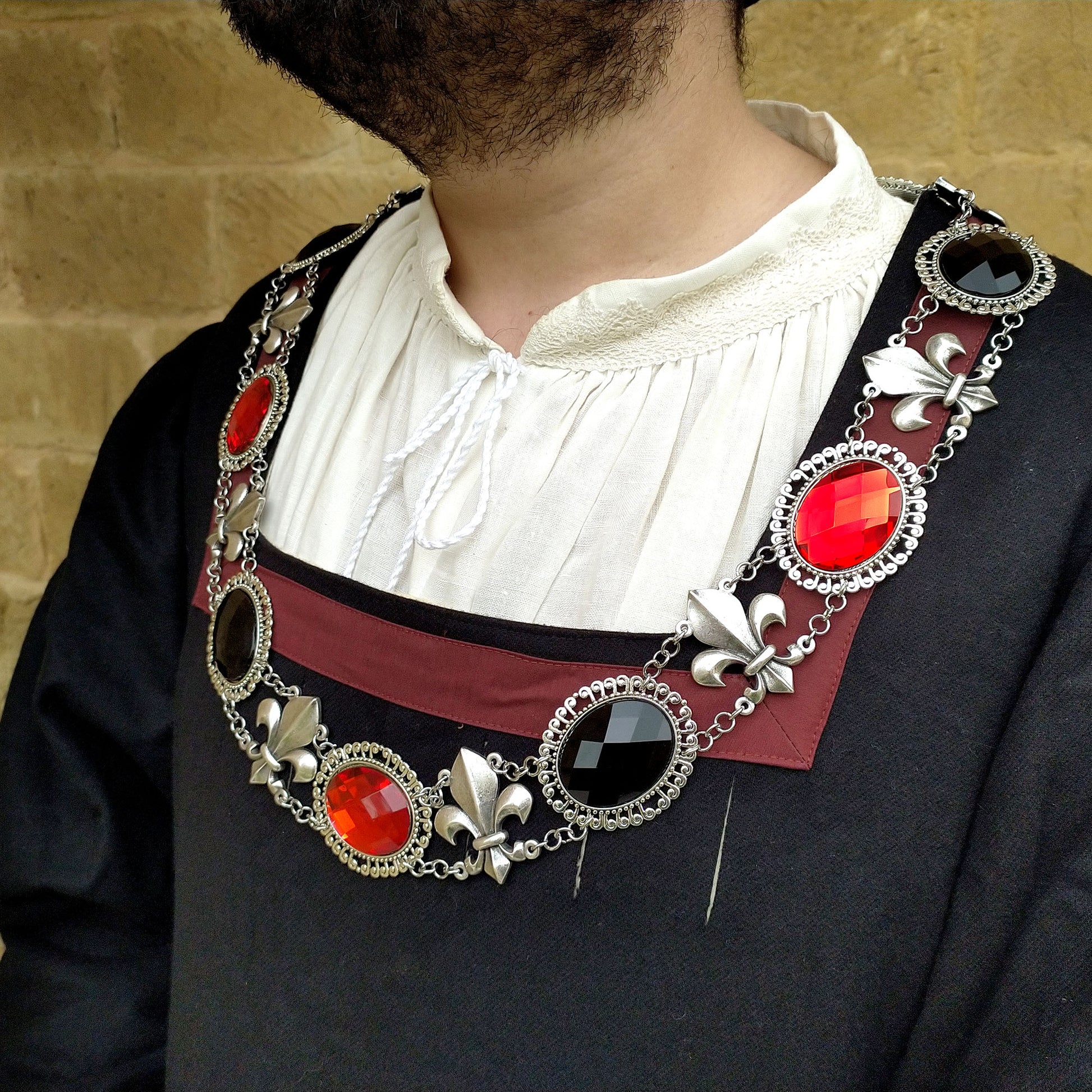 Large chain of office, featuring an antique silver finish and a lateral view of this elegant collar on a model adorned in Renaissance attire. Inspired by the grandeur of the Renaissance, this piece adds a touch of history to any reenactment or fair.