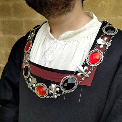 Large chain of office, featuring an antique silver finish and a lateral view of this elegant collar on a model adorned in Renaissance attire. Inspired by the grandeur of the Renaissance, this piece adds a touch of history to any reenactment or fair.