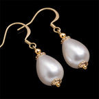 Close up daigonal image of drop pearl earrings on a pure black background