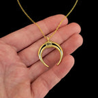 Close up detail of the pendant of Lunula roman necklace over a hand