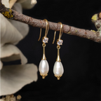 Close up lateral Alexandrine Earrings hanging on a tree branch
