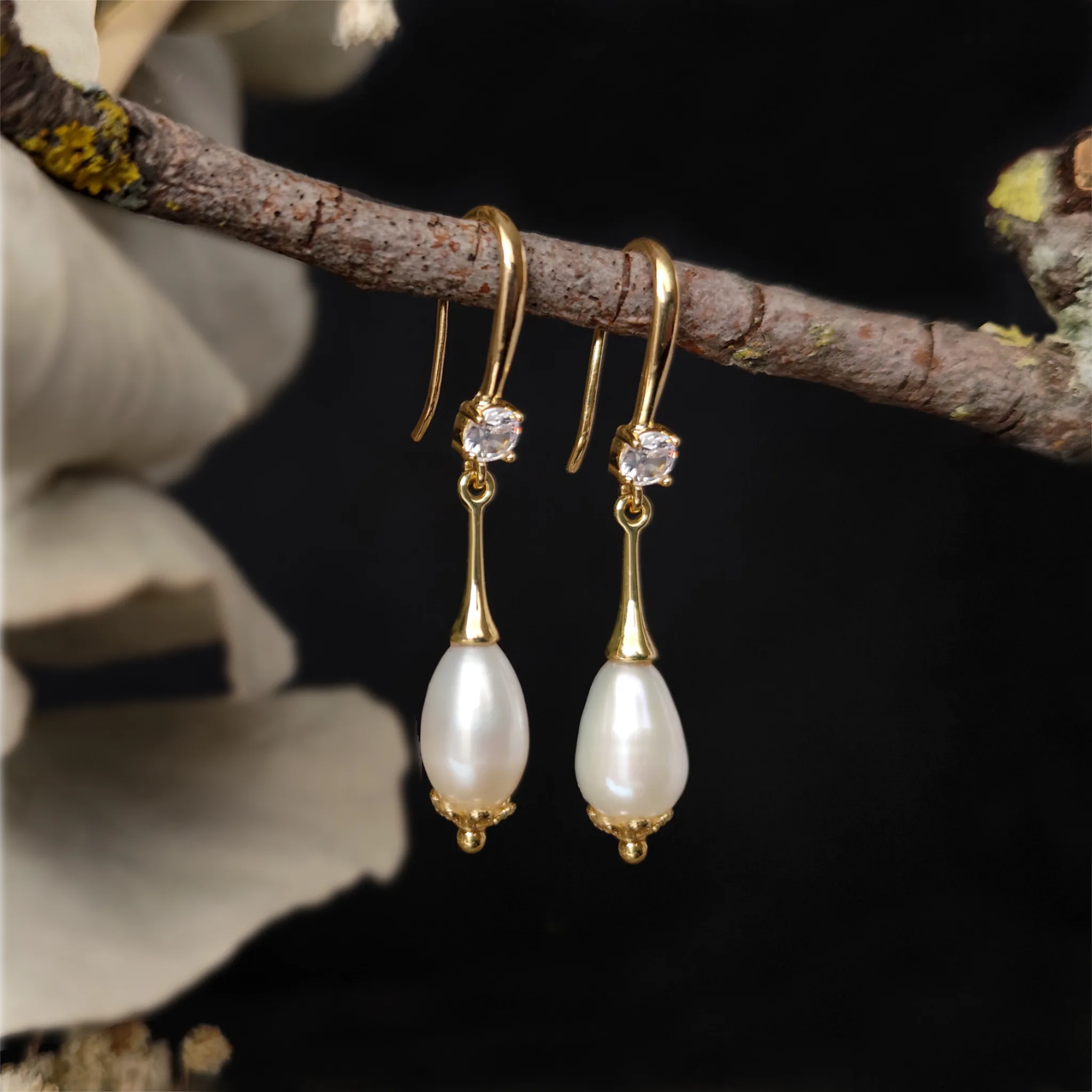 Close up lateral Alexandrine Earrings hanging on a tree branch