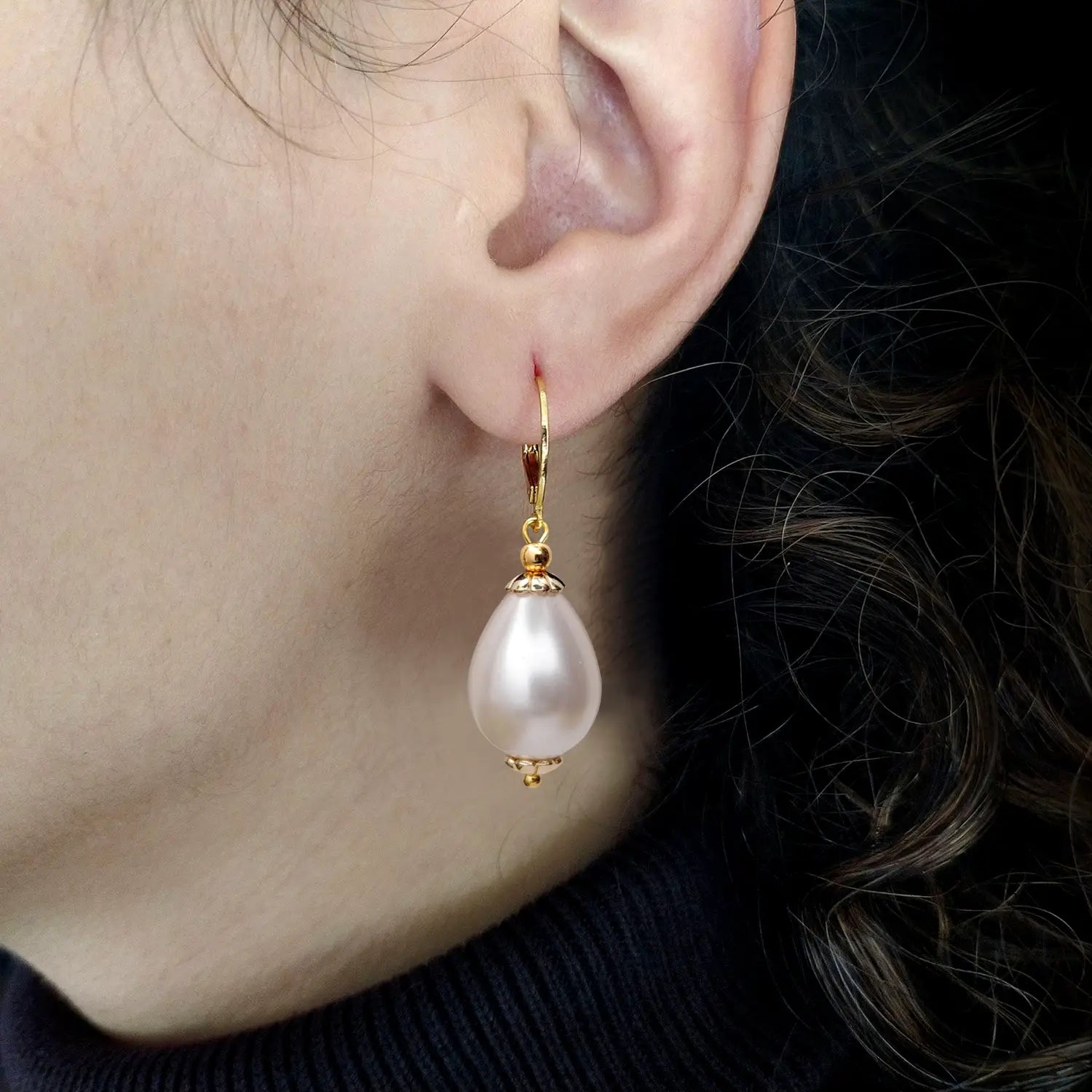 Drop pearl Eleonora earrings on an ear model lateral view