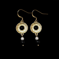 Side view of Virgilia gold plated circular onyx earrings with pearl drops on black background and french hooks