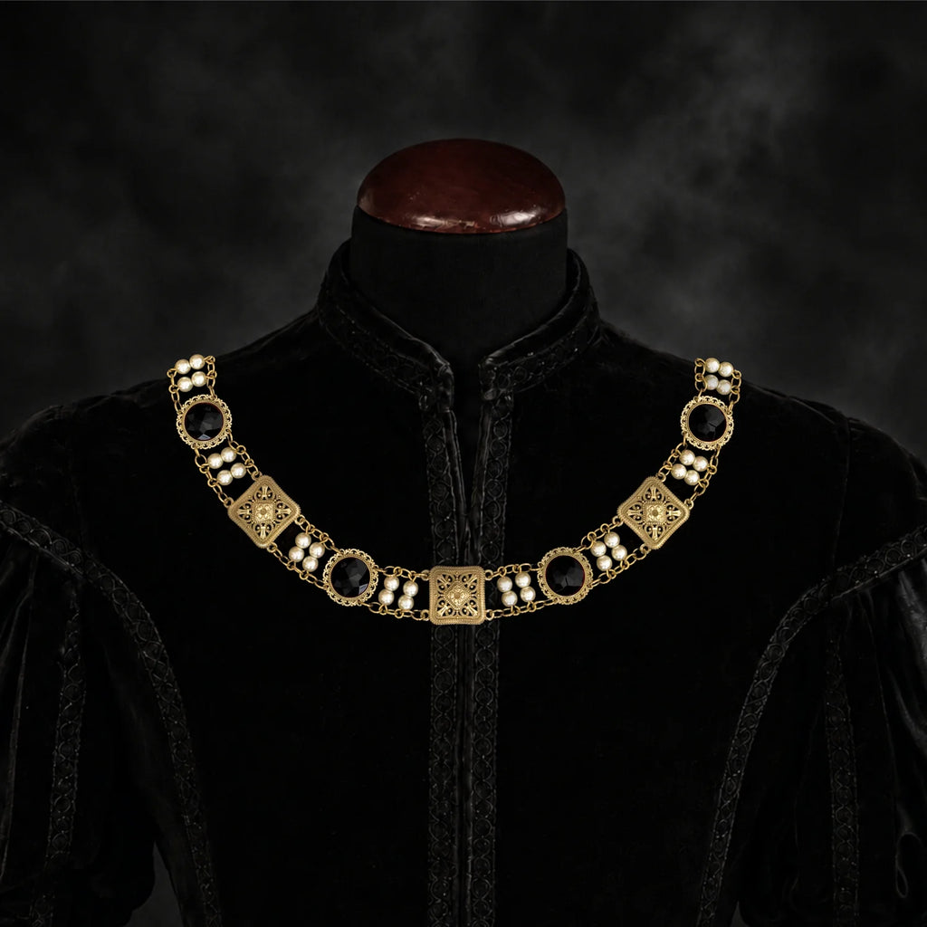 Frontal view of Ambrossio chain of foffice in brass finish with two strand of pearls and Black cabochons on a black doublet mannequin