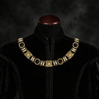 Frontal view of Ambrossio chain of foffice in brass finish with two strand of pearls and Black cabochons on a black doublet mannequin