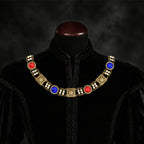 Frontal view of Ambrossio chain of foffice in brass finish with two strand of pearls and Red and blue cabochons on a black doublet mannequin
