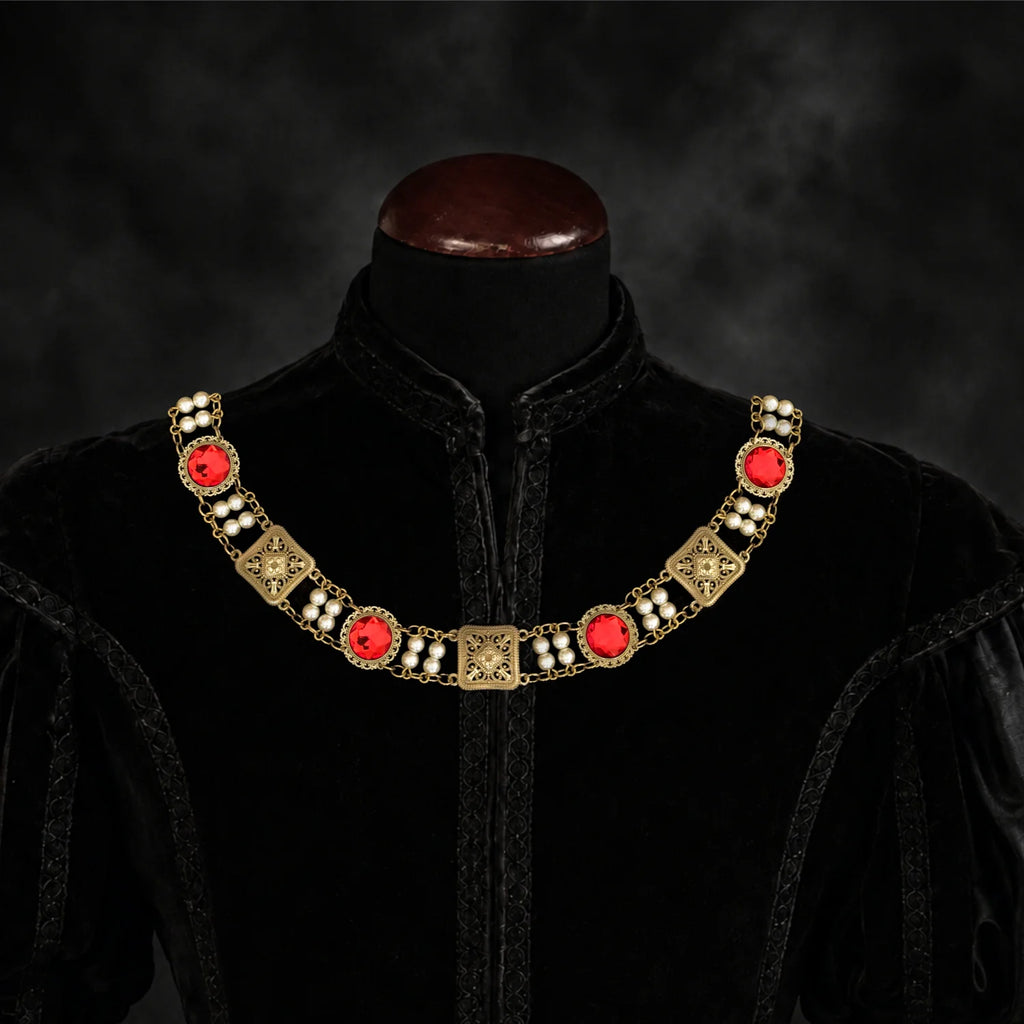 Frontal view of Ambrossio chain of foffice in brass finish with two strand of pearls and Red cabochons on a black doublet mannequin