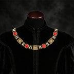 Frontal view of Ambrossio chain of foffice in brass finish with two strand of pearls and Red cabochons on a black doublet mannequin