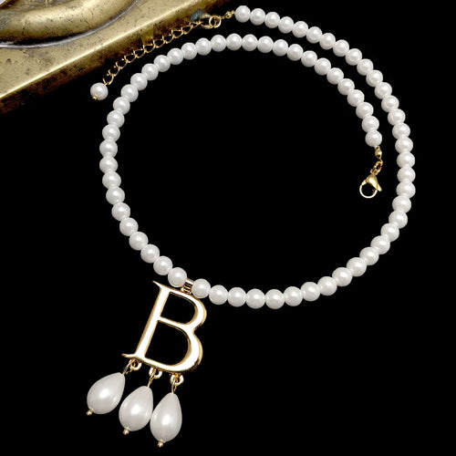 Anne Boleyn B pearl necklace replica with white faux pearls on black background