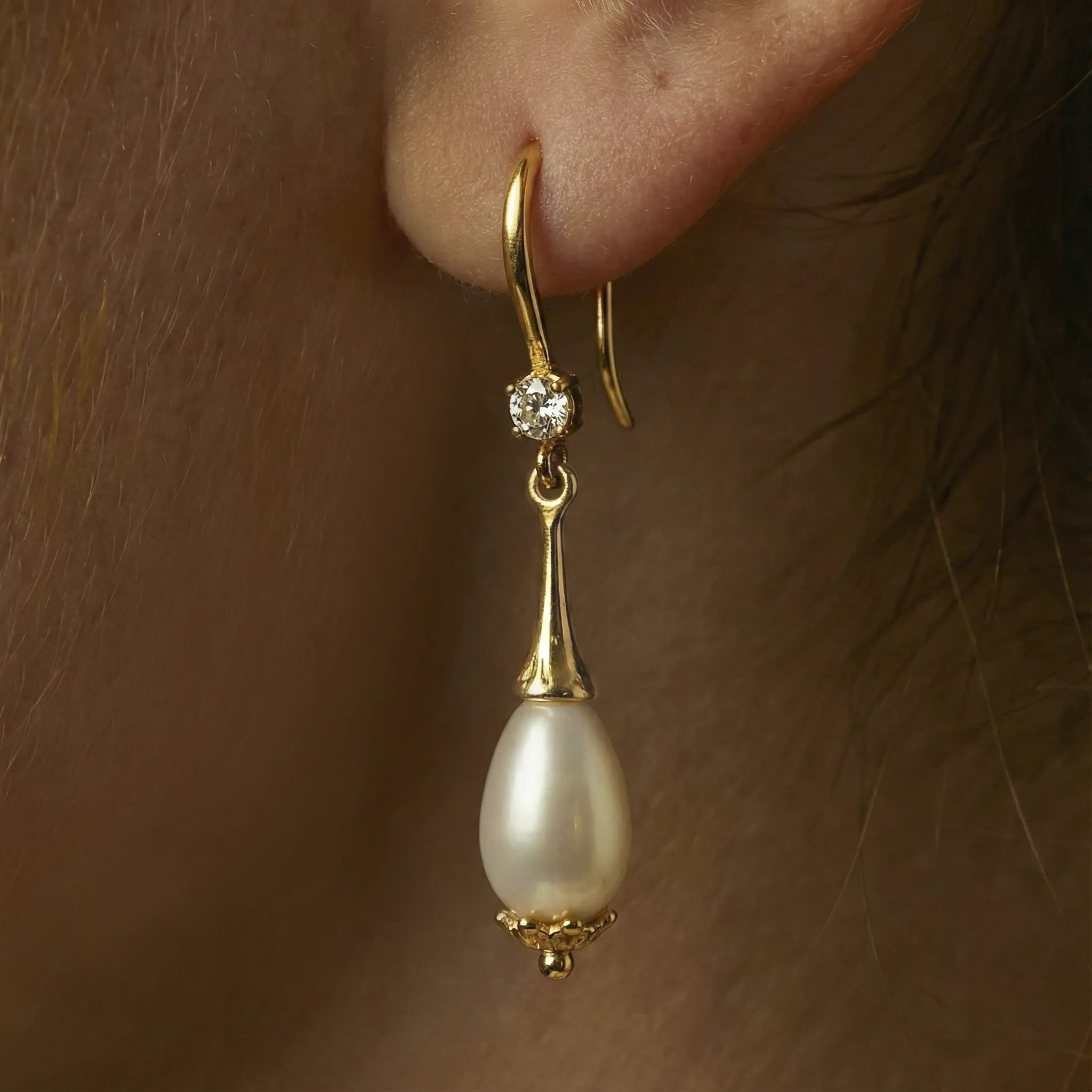 Very Close up of Alesandrine earrings on an ear model